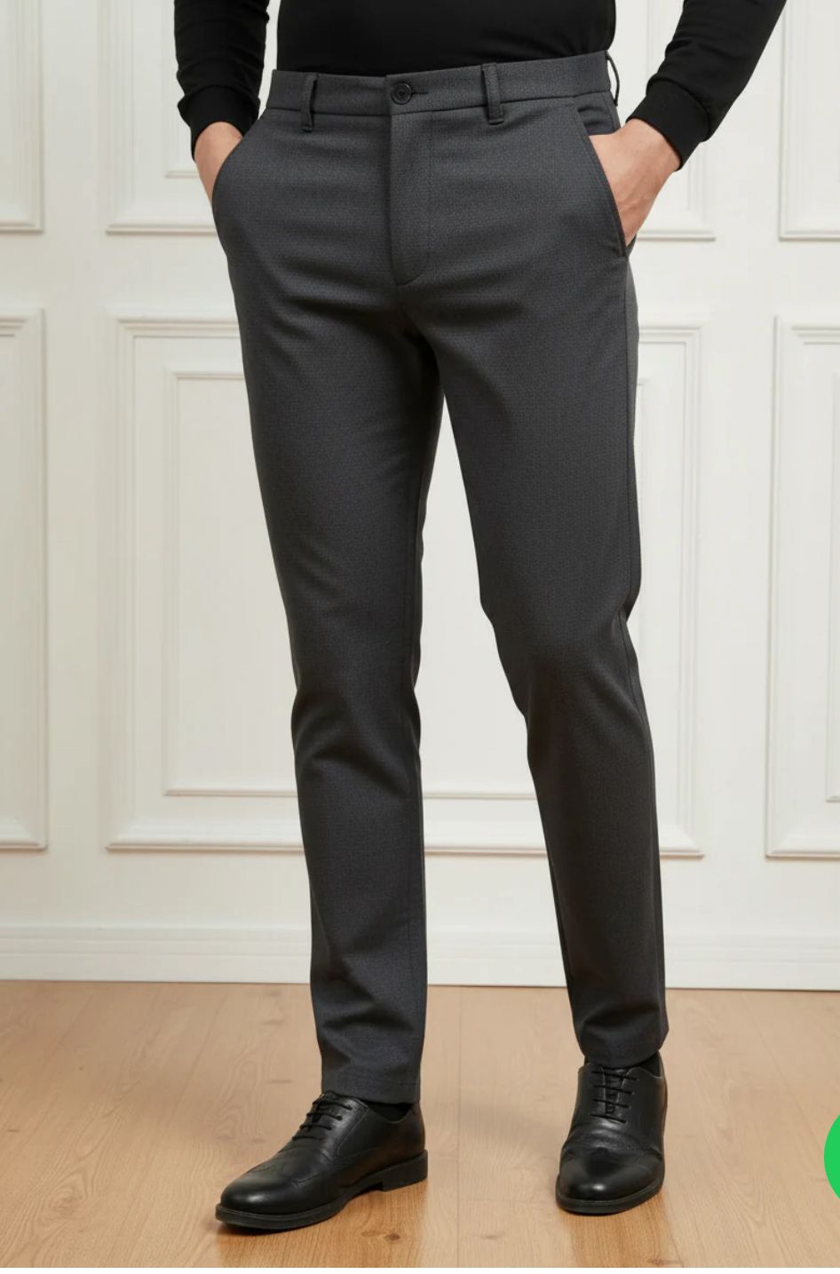 Person wearing gray dress pants with a white wall background